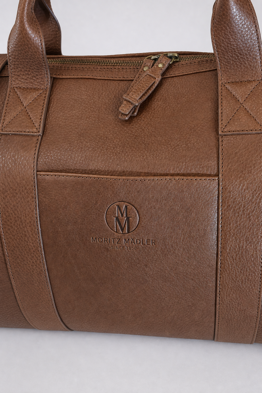 Weekender MM055 in Cognac – Detailaufnahme der Moritz-Mädler-Prägung auf der Fronttasche